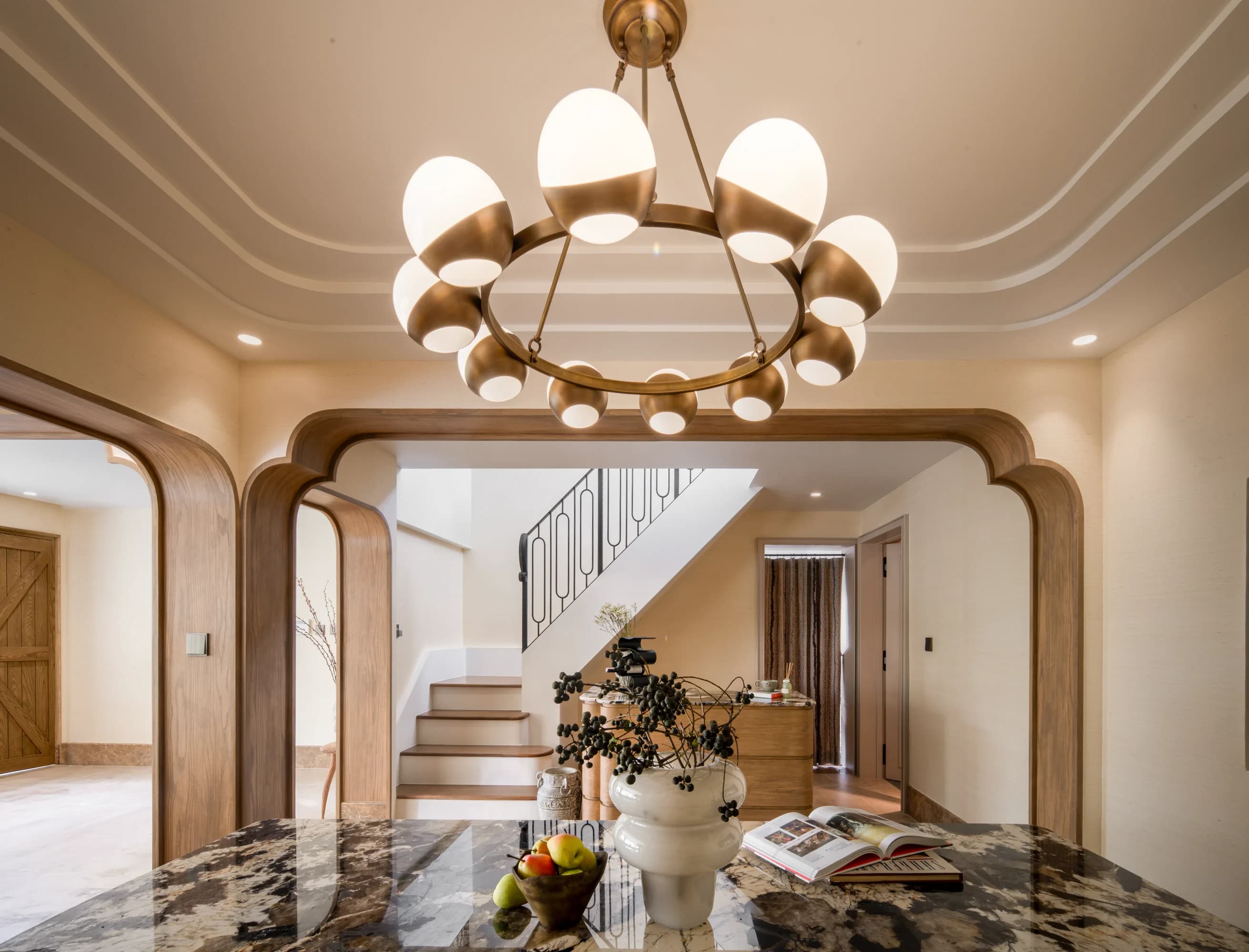 SIWA residence dining room with a sculptural chandelier and softly rounded timber arches