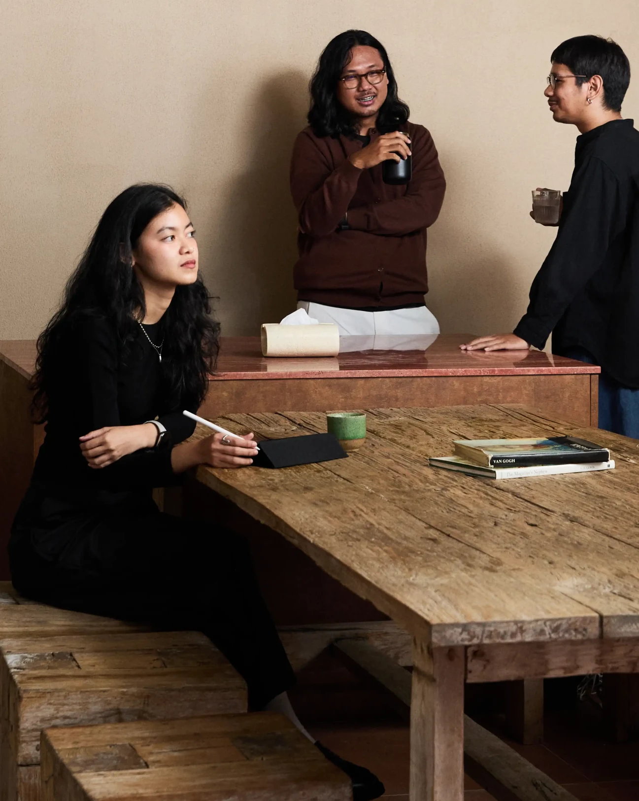 Designers discussing project around wooden table
