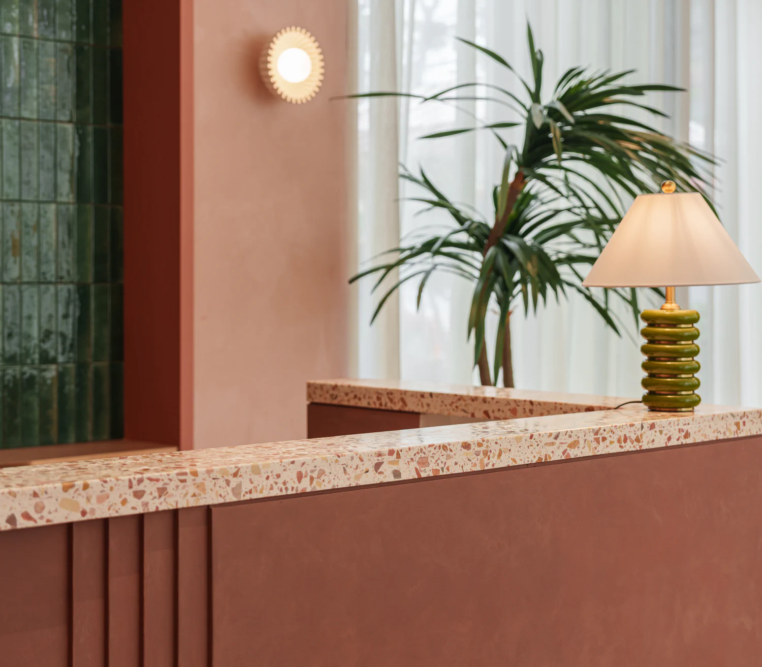 Warm terracotta reception interior with a sculptural table lamp
