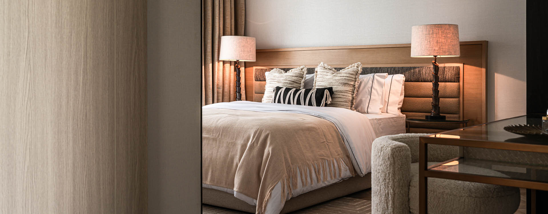 Warm neutral bedroom viewed through a timber doorway